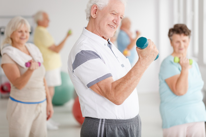 Older man in sportswear training together with his friends using dumbbells